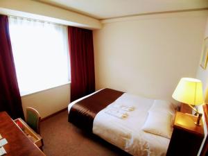 Postel nebo postele na pokoji v ubytování Tokyo Grand Hotel