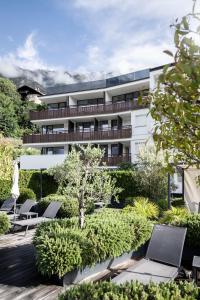 un edificio de apartamentos con tumbonas y un patio en Hotel Belvedere - Adults Only - 14 plus, en Naturno