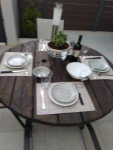 - une table en bois avec des assiettes et des verres à vin dans l'établissement Arxontia 2, à Kalamata