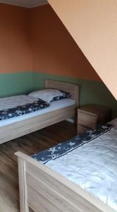 two beds in a room with green walls at Monteurzimmer/Ferienwohnung Roßheidestraße, Gladbeck in Gladbeck