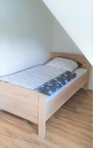 a bed with a wooden frame in a room at Monteurzimmer/Ferienwohnung Roßheidestraße, Gladbeck in Gladbeck