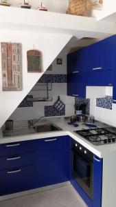 モンテロッソ・アル・マーレにあるChiara Cosy Studio Flat with ACの青と白のキッチン(コンロ付)