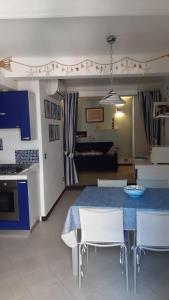 una cucina e un soggiorno con tavolo e sedie blu di Chiara Cosy Studio Flat with AC a Monterosso al Mare