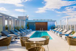 a rooftop patio with chairs and a pool on a building at Hotel Indigo Larnaca, an IHG Hotel-ADULTS ONLY in Larnaka