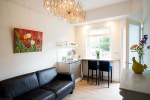 a living room with a couch and a kitchen at Slapen bij Jesse in Broek in Waterland