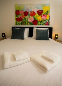 łóżko z dwoma ręcznikami i obrazem w obiekcie Slapen bij Jesse w mieście Broek in Waterland