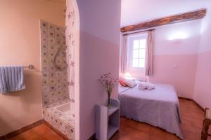 a small bedroom with a bed and a shower at Maison coeur de village Ramatuelle in Ramatuelle