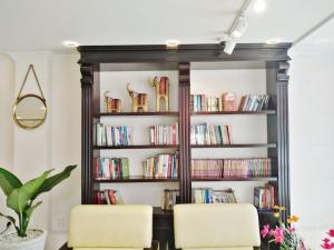 two chairs in front of a book shelf with books at CONVOI HOTEL in Can Tho