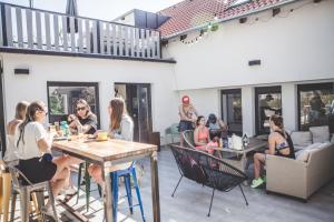 um grupo de pessoas sentadas em torno de uma mesa em um pátio em Patent, your home in Badacsony em Badacsonytomaj