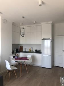 a kitchen with a table and chairs and a refrigerator at Apartament Grażyna Stańczyka in Warsaw