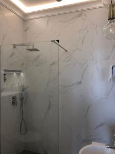 La salle de bains est pourvue d'une douche en verre et d'un lavabo. dans l'établissement Apartament Grażyna Stańczyka, à Varsovie