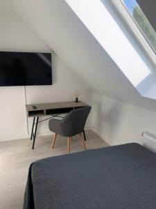 1 dormitorio con escritorio, TV y silla en Just-Sleep, en Brande