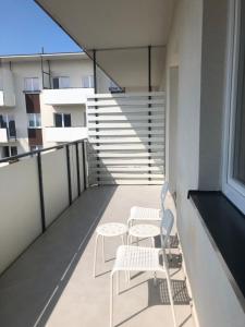 a balcony with two chairs and tables on a building at Apartament Grażyna Stańczyka in Warsaw