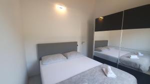 a small bedroom with two beds and a mirror at Penthouse Avangard in Pag