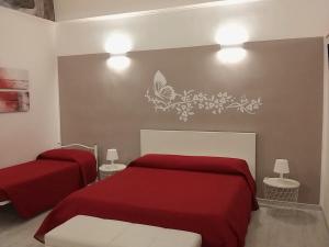 マテーラにあるCasa Du Mattneerのベッドルーム1室(赤いベッド2台、壁に蝶付)