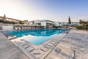 una piscina con acqua blu di fronte a un edificio di Hapimag Resort Porto Heli a Porto Heli