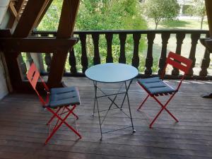 two chairs and a table on a porch at Chambre de la Vigne in Blesmes