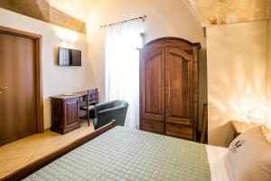 a bedroom with a bed and a desk and a chair at Laurito Resort & Spa in Oria