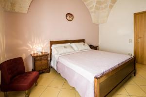 1 dormitorio con 1 cama y 1 silla roja en Laurito Resort & Spa, en Oria