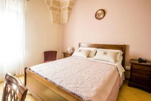 1 dormitorio con 1 cama y reloj en la pared en Laurito Resort & Spa, en Oria