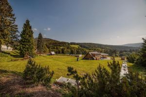 a green field with a house in the distance at Pension Valja in Janske Lazne