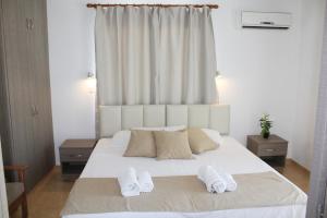 a bedroom with a large white bed with two pillows at Maria Zintili Apartments in Ayia Napa