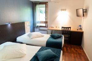 Postelja oz. postelje v sobi nastanitve Hôtel Bagatelle Paris Nord Roissy CDG