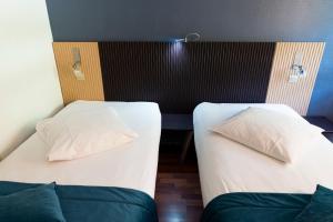 Postelja oz. postelje v sobi nastanitve Hôtel Bagatelle Paris Nord Roissy CDG