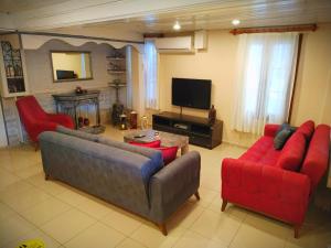 a living room with two couches and a tv at Yalcin Hotel in Çeşme