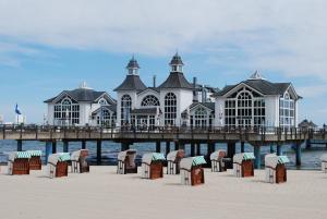 a building on the beach with chairs and a pier at Villa Anna in Ostseebad Sellin
