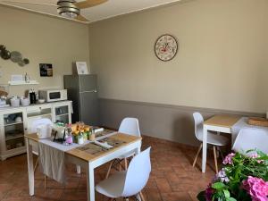 a dining room with a table and white chairs at B&B dalLo Zio in Ottobiano