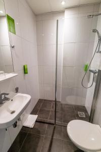 een badkamer met een douche en een wastafel bij Court Garden Hotel - Ecodesigned in Den Haag