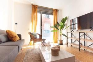 ein Wohnzimmer mit einer Couch und einem Tisch in der Unterkunft Heima Gran Vía A in Madrid