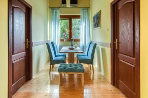 jadalnia ze stołem i niebieskimi krzesłami w obiekcie DuMalux apartment w mieście Subotica