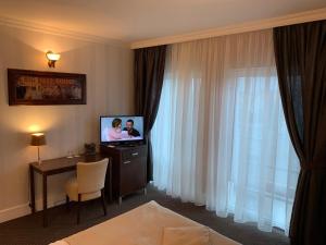 a hotel room with a television and a table with a chair at Pension Eden in Želiezovce