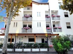 ein weißes Gebäude mit Blumen auf den Balkonen in der Unterkunft Hotel Sasselli Dipendenza Hotel Zamagna in Cesenatico