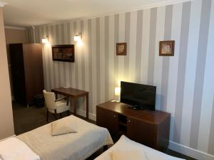 a hotel room with two beds and a television at Pension Eden in Želiezovce