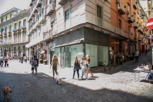 un groupe de personnes marchant dans une rue avec un chien dans l'établissement Appartament Home Maria, à Naples