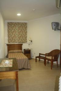 a bedroom with a bed and a table and a chair at Hotel PARAISO PLAYA in Isla Cristina