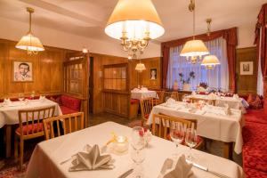 a restaurant with white tables and chairs and chandeliers at Hotel-Restaurant Ochsen in Blaubeuren