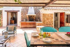 a patio with a table and chairs and a fireplace at Villa Ginepro con Piscina Privata in San Teodoro