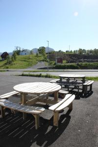un grupo de mesas de picnic en un estacionamiento en Joker Bø, en Bø i Vesterålen