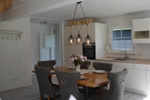 eine Küche und ein Esszimmer mit einem Holztisch und Stühlen in der Unterkunft Kapitänshaus Zerpenschleuse Holiday Chalet in Wandlitz