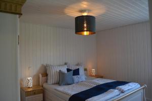 Schlafzimmer mit einem Bett mit blauen und weißen Kissen in der Unterkunft Kapitänshaus Zerpenschleuse Holiday Chalet in Wandlitz