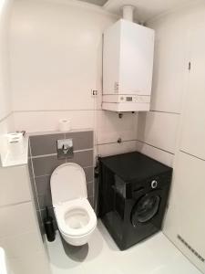 a small bathroom with a toilet and a washing machine at Theos atelier SELF CHECK IN APARTMENT w Free Private Parking in Zagreb