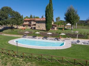 a large swimming pool in a yard with a house at Agriturismo Quata Country House in Borgo alla Collina