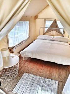 En eller flere senge i et værelse på Canopy Villa Glamping Park