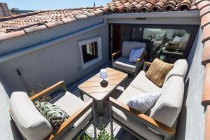 a balcony with chairs and a table on a roof at DUPLEX MIRABEAU - Roof terrace with panoramic view in Aix-en-Provence