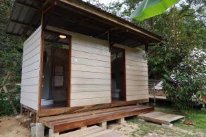 Kampong Sum Sum的住宿－Canopy Villa Glamping Park，一个小房子,设有门廊和长凳