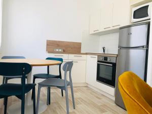 eine Küche mit Tisch und Stühlen und einem Kühlschrank in der Unterkunft Artimon Beach appart Les Sables d Olonne in Les Sables-dʼOlonne + 7 Fotos